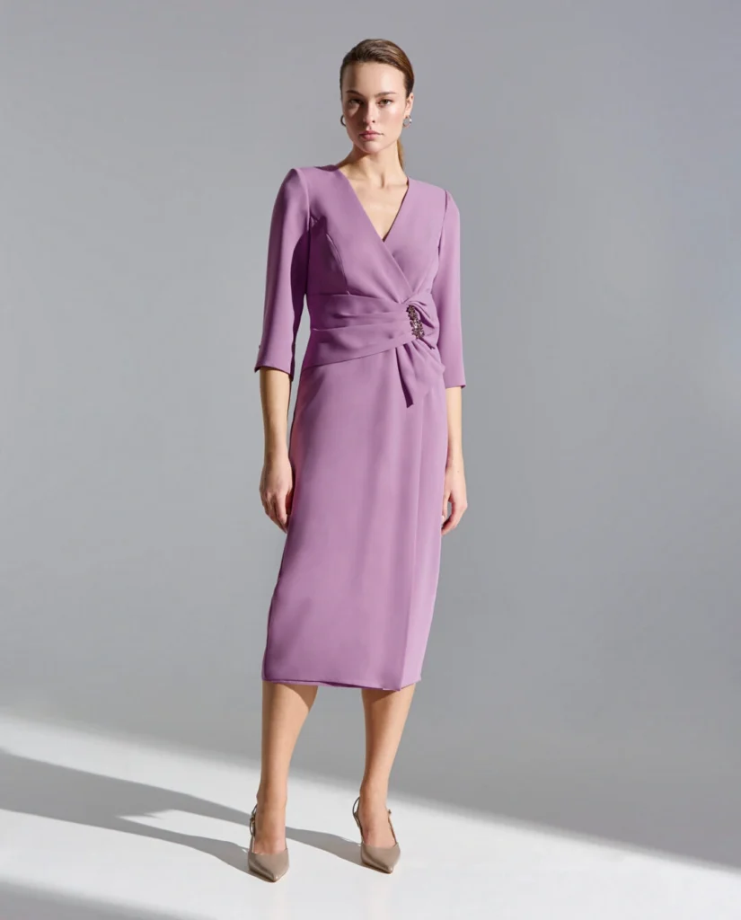 Vestido midi en crep, escote en pico y mangas francesas. Destaca el detalle fruncido en la cintura con aplique joya central